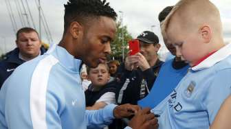 Pemain baru Manchester City Raheem Sterling membubuhkan tanda tangan untuk suporternya di Etihad Stadium. Reuters/Andrew Yates