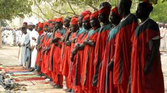 Sekelompok pemburu lokal tampak bergabung dengan umat Muslim dalam melaksanakan salat Idul Fitri di Kano, Nigeria, Jumat (17/7/2015). [Reuters/Stringer]