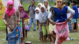 Anak-anak warga Muslim saling bergembira lewat ajang pacu karung, dalam rangka perayaan Idul Fitri, di Manila, Filipina, Sabtu (18/7/2015). [Reuters/Romeo Ranoco]