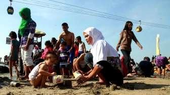 Pengunjung tampak berenang dan menikmati aktivitas liburan di Pantai Ancol, Jakarta, Minggu (19/7/2015). [Suara.com/Oke Atmaja]