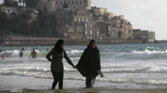 Masyarakat Palestina yang bermukim di Tepi Barat memadati pantai pesisir Laut Mediterania, (19/7), bertepatan dengan hari ketiga perayaan Hari Raya Idul Fitri 1436H. [Reuters/Baz Ratner]