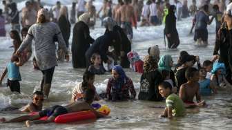 Masyarakat Palestina yang bermukim di Tepi Barat memadati pantai pesisir Laut Mediterania, (19/7), bertepatan dengan hari ketiga perayaan Hari Raya Idul Fitri 1436H. [Reuters/Baz Ratner]