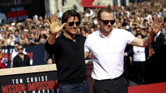 Tom Cruise menyapa dan berfoto bersama para penggemar saat tiba di acara pemutaran perdana film terbarunya yang berjudul Mission Impossible - Rogue Nation di Wina, Austria, (23/7). [Reuters/Leonhard Foeger]