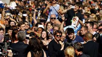 Tom Cruise menyapa dan berfoto bersama para penggemar saat tiba di acara pemutaran perdana film terbarunya yang berjudul Mission Impossible - Rogue Nation di Wina, Austria, (23/7). [Reuters/Leonhard Foeger]