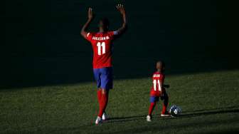 Striker baru Atletico Jackson Martinez bersama anaknya saat diperkenalkan ke publik. Reuters/Susana Vera