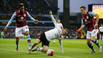 Dua pemain Aston Villa mencoba merebut bola dari kapten MU Wayne Rooney (tengah) (15/8) [Reuters/Darren Staples]