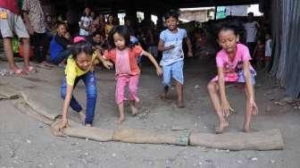 Masyarakat, termasuk anak-anak, mengikuti perayaan HUT Kemerdekaan Republik Indonesia yang ke-70 Tahun di kawasan kolong jembatan layang Lodan, Kampung Bandan, Jakarta, Senin (17/8). [Suara.com/Kurniawan Mas'ud]