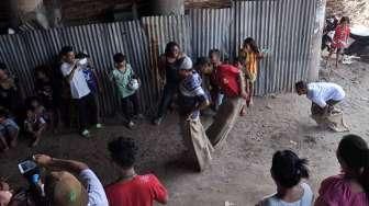 Masyarakat, termasuk anak-anak, mengikuti perayaan HUT Kemerdekaan Republik Indonesia yang ke-70 Tahun di kawasan kolong jembatan layang Lodan, Kampung Bandan, Jakarta, Senin (17/8). [Suara.com/Kurniawan Mas'ud]