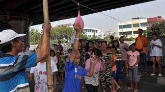 Masyarakat, termasuk anak-anak, mengikuti perayaan HUT Kemerdekaan Republik Indonesia yang ke-70 Tahun di kawasan kolong jembatan layang Lodan, Kampung Bandan, Jakarta, Senin (17/8). [Suara.com/Kurniawan Mas'ud]