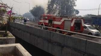 Petugas memadamkan api yang melalap permukiman liar di bawah jembatan layang Kuningan, Jakarta, Rabu (19/8). [Suara.com/Kurniawan Mas'ud]