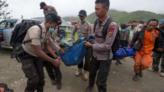 Petugas SAR gabungan menurunkan jenazah korban kecelakaan pesawat Trigana Air dari mobil setibanya di RSUD Oksibil, Kabupaten Pegunungan Bintang, Papua, Rabu (19/8/2015). [Antara/Andika Wahyu]