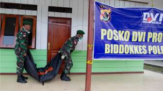 Prajurit TNI membawa kantong mayat kosong di RSUD Oksibil, Kabupaten Pegunungan Bintang, Papua, Rabu (19/8/2015). [Antara/Andika Wahyu]