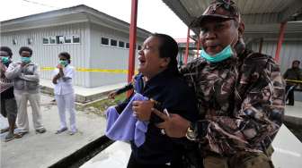 Keluarga korban kecelakaan pesawat Trigana Air menangis histeris saat jenazah yang dibawa tim SAR gabungan tiba di RSUD Oksibil, Kabupaten Pegunungan Bintang, Papua, Rabu (19/8/2015). [Antara/Andika Wahyu]