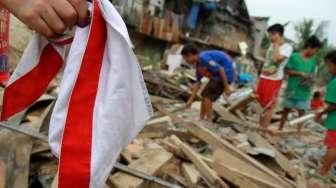 Sejumlah warga Kampung Pulo mencari harta bendanya yang tersisa, di puing-puing bangunan rumahnya yang dibongkar aparat di Jakarta, Kamis (20/8/2015). [Suara.com/Oke Atmaja]