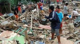 Sejumlah warga Kampung Pulo mencari harta bendanya yang tersisa, di puing-puing bangunan rumahnya yang dibongkar aparat di Jakarta, Kamis (20/8/2015). [Suara.com/Oke Atmaja]