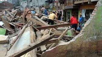 Sejumlah warga Kampung Pulo mencari harta bendanya yang tersisa, di puing-puing bangunan rumahnya yang dibongkar aparat di Jakarta, Kamis (20/8/2015). [Suara.com/Oke Atmaja]