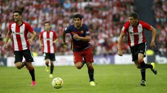 Striker Barcelona Luis Suarez (tengah) membawa bola ditempel pemain Athletic Bilbao. Reuters/Joseba Etxaburu