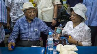 Mantan Perdana Menteri Malaysia, Mahathir Mohamad dan istrinya, Siti Hasmah, ikut berdemonstrasi untuk menurunkan PM Najib Razak di Kuala Lumpur, Minggu (30/8) [Reuters/Athit Perawongmetha].