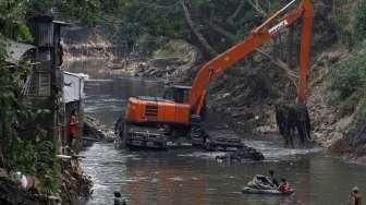 Petugas dibantu TNI melakukan pengerukan Sungai Ciliwung di kawasan kampung Pulo-Bukit Duri, Jakarta, Minggu (6/9).[Suara.com/Kurniawan Mas'ud]