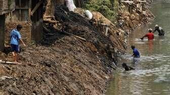 Petugas dibantu TNI melakukan pengerukan Sungai Ciliwung di kawasan kampung Pulo-Bukit Duri, Jakarta, Minggu (6/9).[Suara.com/Kurniawan Mas'ud]