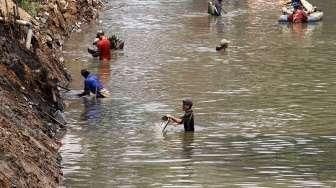 Petugas dibantu TNI melakukan pengerukan Sungai Ciliwung di kawasan kampung Pulo-Bukit Duri, Jakarta, Minggu (6/9).[Suara.com/Kurniawan Mas'ud]