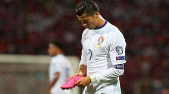 Kapten Portugal Cristiano Ronaldo memegang sepatunya. Reuters/Arben Celi