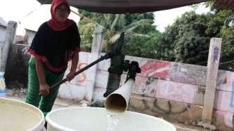 Sejumlah warga tampak bergiliran memompa air di sebuah pompa manual yang ada di Kelurahan Kebon Melati, Tanah Abang, Jakarta, Sabtu (26/9/2015). [Suara.com/Oke Atmaja]