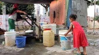 Sejumlah warga tampak bergiliran memompa air di sebuah pompa manual yang ada di Kelurahan Kebon Melati, Tanah Abang, Jakarta, Sabtu (26/9/2015). [Suara.com/Oke Atmaja]