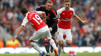 Striker Manchester United Wayne Rooney ditempel dua pemain Arsenal Aaron Ramsey dan Santi Cazorla. Reuters / Carl Recine Livepic