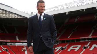 David Beckham berpose di Old Trafford menjelang laga amal untuk Unicef. Reuters/ Andrew Yates