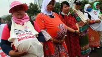 Para aktivis dari Komite Perempuan Industrial Indonesian Council melakukan aksi di depan Istana Negara, Jakarta, Rabu (7/10/2015). [Suara.com/Oke Atmaja]