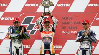 Pebalap MotoGP Honda Dani Pedrosa (tengah) mengangkat trofi kemenangannya di Jepang dan juga ke-50 di grand prix. Reuters/Issei Kato