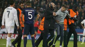 Seorang fans memasuki arena pertandingan dan memeluk Ronaldo saat PSG menjamu Real Madrid (22/10)[Reuters/Charles Platiau]