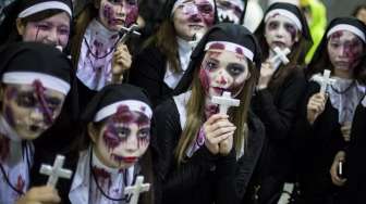 Sejumlah perempuan mengenakan kostum biarawati bertampang seram dalam perayaan Halloween di Shibuya, Jepang. [Reuters/Thomas Peter]