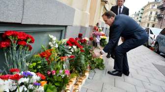 Perdana Menteri Swedia, Stefan Lofven, meletakkan setangkai mawar merah di luar Kedubes Prancis di Stockholm, Sabtu (14/11/2015), terkait insiden serangan Paris. [Reuters/Johan Nilsson]