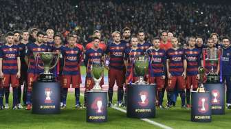 Para pemain Barcelona berpose dengan lima trofi yag mereka raih di 2015. Reuters/Stringer