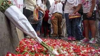 Sejumlah keluarga korban bom terorisme yang tergabung dalam Aliansi Indonesia Damai (AIDA) melakukan aksi tabur bunga di lokasi teror Jalan MH Thamrin, Jakarta, Minggu (17/1/2016). [Suara.com/Kurniawan Mas'ud]