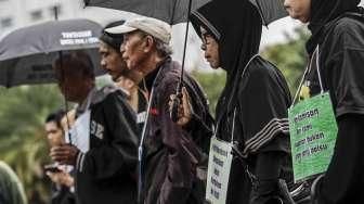 Anggota Jaringan Solidaritas Korban untuk Keadilan membagikan bunga kepada personel polisi dalam acara refleksi 