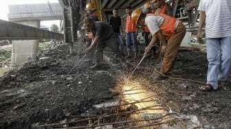 Petugas dibantu alat berat melakukan pembongkaran jembatan permanen yang menghubungkan batas wilayah Cawang-Cililitan di Kalibata, Jakarta, Senin (7/3/2016). [Suara.com/Kurniawan Mas'ud]