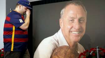 Seorang fans Barcelona tampak menangis di depan foto Johan Cruyff di Camp Nou. Reuters/Albert Gea