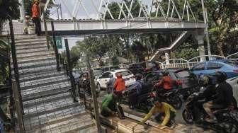 Pekerja menyelesaikan proyek pembangunan Jembatan Penyeberangan Orang (JPO) di Jalan Dr Soepomo, Tebet, Jakarta, Selasa (19/4/2016). [Suara.com/Kurniawan Mas'ud]