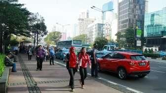 Sejumlah pejalan kaki tampak berjalan di trotoar kawasan Jalan Sudirman, Jakarta, Selasa (19/4/2016). [Suara.com/Oke Atmaja]