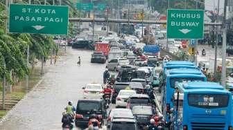 Suasana genangan air dan kondisi lalu lintas di kawasan Jalan Gunung Sahari Raya, Pademangan, Sawah Besar, Jakarta, Kamis (21/4/2016). [Suara.com/Oke Atmaja]