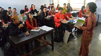 Siswa-siswi mengenakan pakaian adat dalam rangka Hari Kartini, saat mengikuti pelajaran di SMA Katolik Santo Paulus, Jember, Jawa Timur, Kamis (21/4/2016). [Antara/Seno]