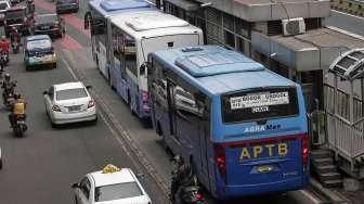 Angkutan Perbatasan Terintegrasi Bus Transjakarta (APTB) saat melintas di jalur busway di kawasan Gatot Soebroto, Jakarta, Senin (23/5). [suara.com/Kurniawan Mas'ud]