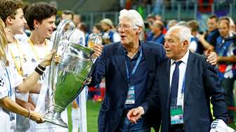 Aktor Richard Gere masuk kelapangan dan memegang trofi setelah Real Madrid memenangi Liga Champions. Reuters/Stefano Rellandini