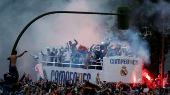 Para pemain Real Madrid menyapa fansnya saat pawai trofi Liga Champions ke Cibeles square. Reuters /Susana Vera