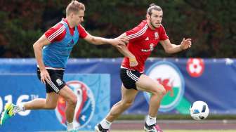 Gareth Bale membawa bola ditempel David Edwards saat sesi latihan. Reuters/Carl Recine