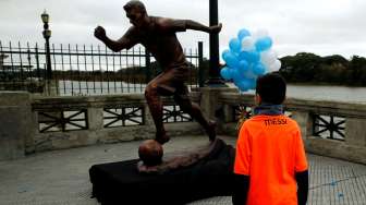 Seorang fans di depan patung Lionel Messi. Reuters/Marcos Brindicci