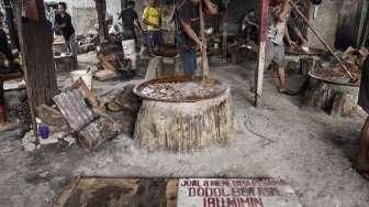 Pekerja memasak adonan dodol di rumah industri olahan dodol Betawi di kawasan Pasar Minggu, Jakarta, Kamis (23/6).[Suara.com/Kurniawan Mas'ud]